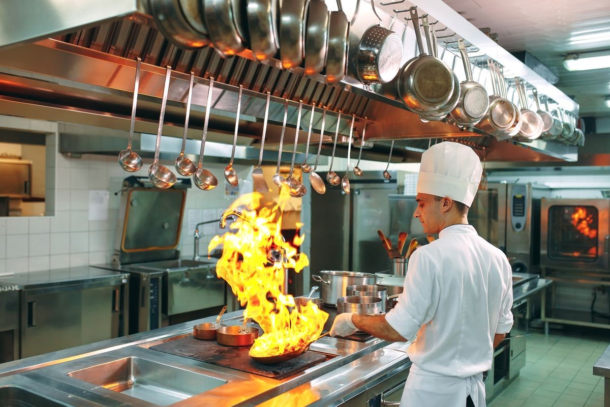 Modern kitchen. Cooks prepare meals on the stove in the kitchen of the restaurant or hotel. The fire in the kitchen
